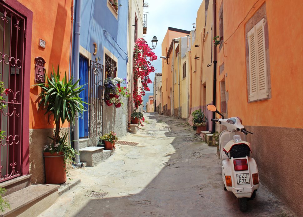 beautifully colored homes in Italy with narrow inclined walkway