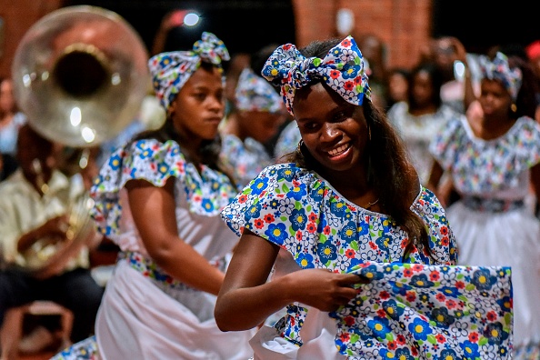 Afro-Colombians dance "Fuga" (Traditional dance) during the "Adoraciones al Nino Dios" celebrations in Quinamayo, department of Valle del Cauca, Colombia, on February 18, 2018. The Adoraciones al Nino Dios are traditional Christmas celebrations of Afro-Colombian communities that have been taking place in February for around 138 years. Slave owners did not allow them to celebrate it in December due to their duties. / AFP PHOTO / Luis ROBAYO (Photo credit should read