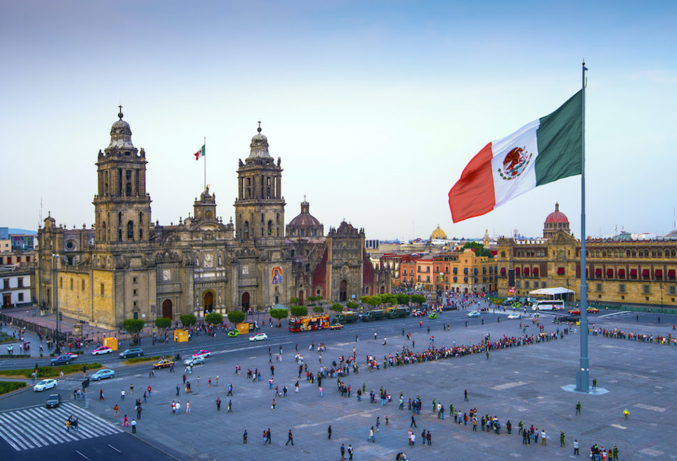 The Mexican flag flies over the Zocalo, the main square in Mexico City.  The Metropolitan Cathedral faces the square, also referred to as Constitution Square.