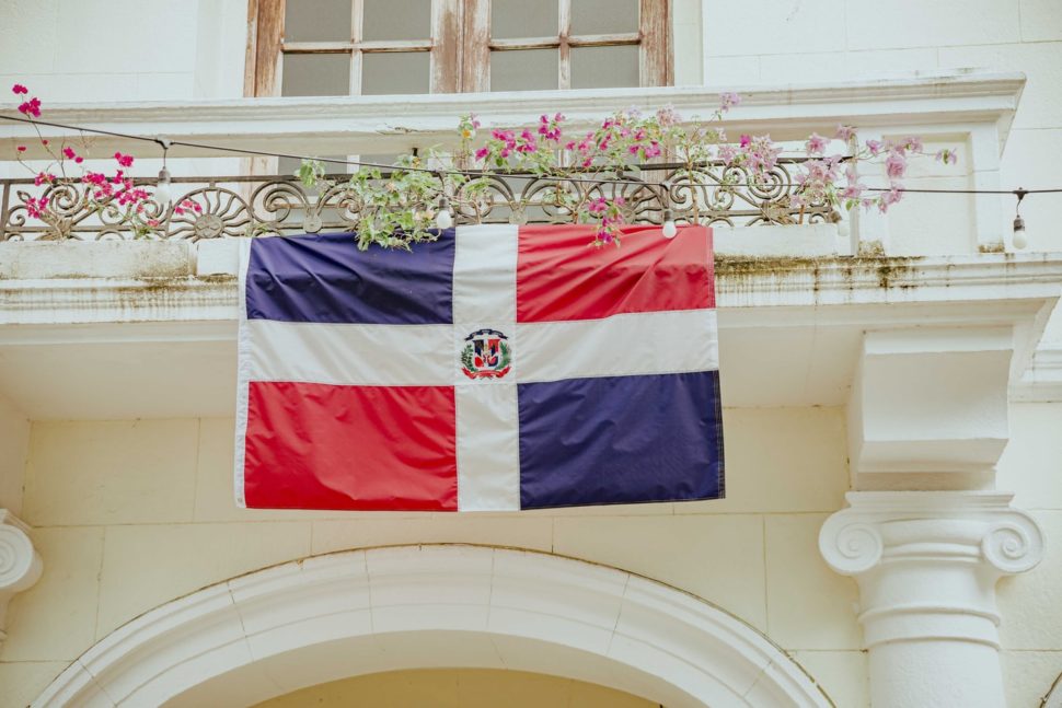 Dominican Republic Flag hanging off balcony of white building