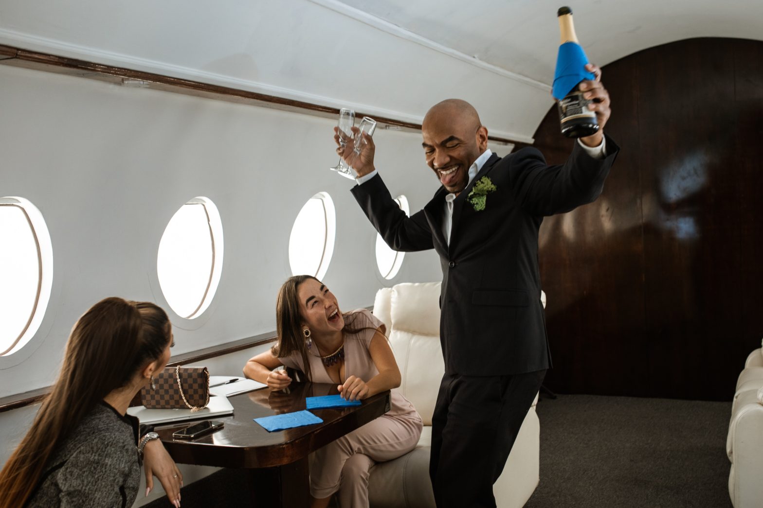 flight attendant holding bottle of champagne on private plane representing the vacation persona quiz