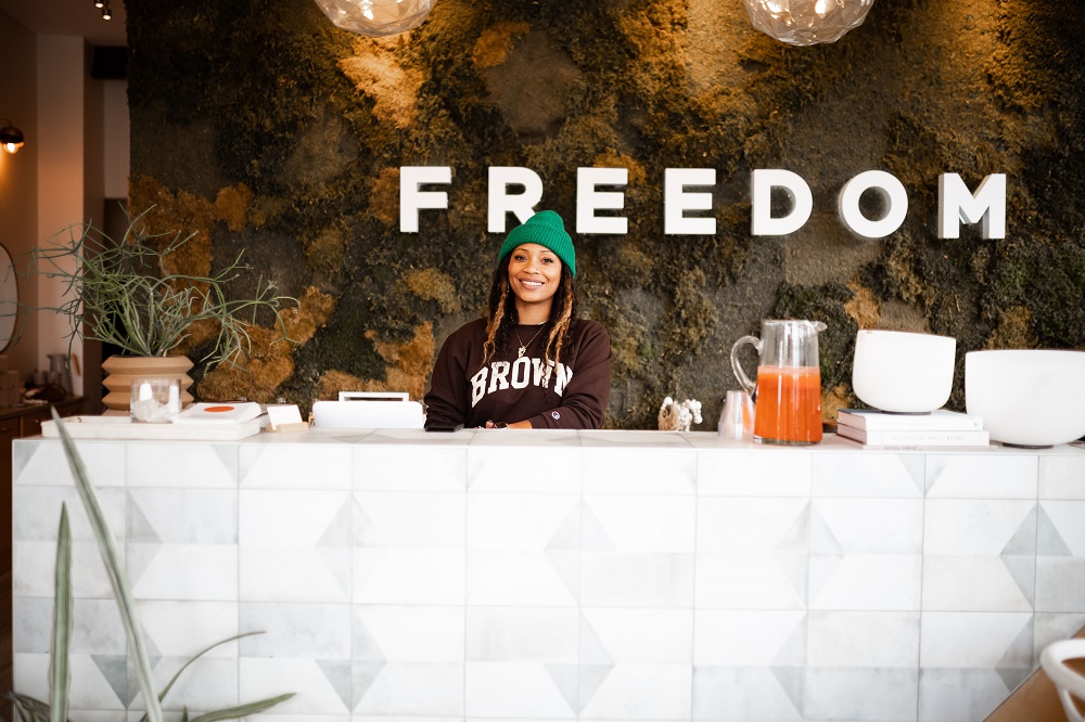 Black woman standing at the welcome desk of Freedom apothecary wellness space