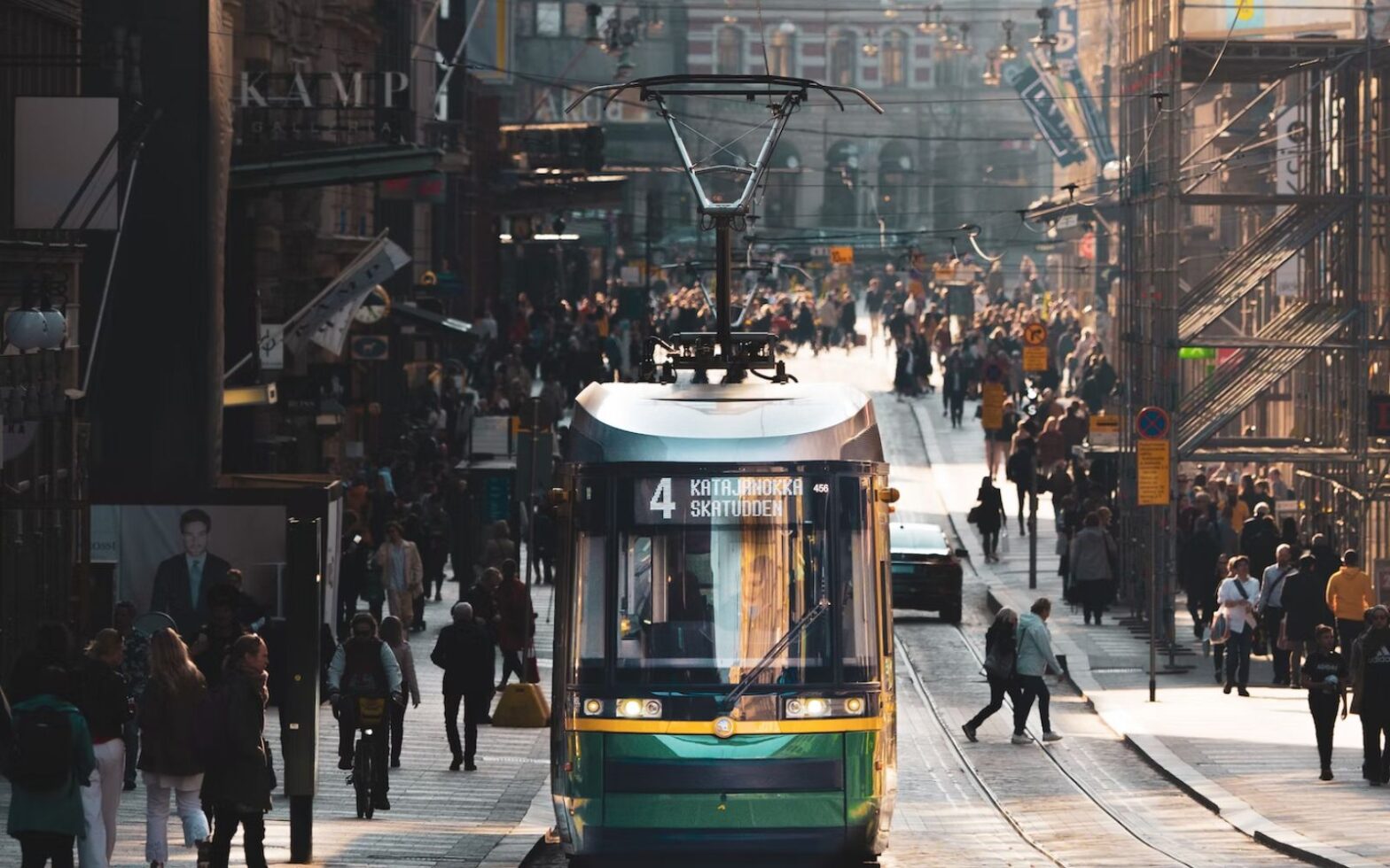 The World’s Happiest Countries in 2023 - image of street view in Helsinki, Finland with trolley on street and people walking throughout the city