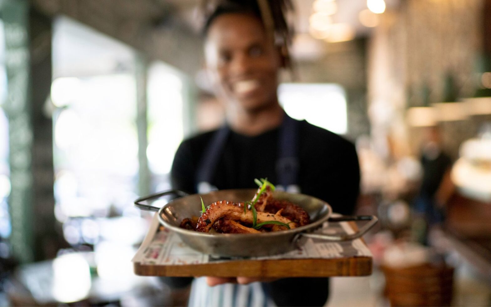Smiling male chef holding prepared dish - Best ethnic restaurant in Atlanta