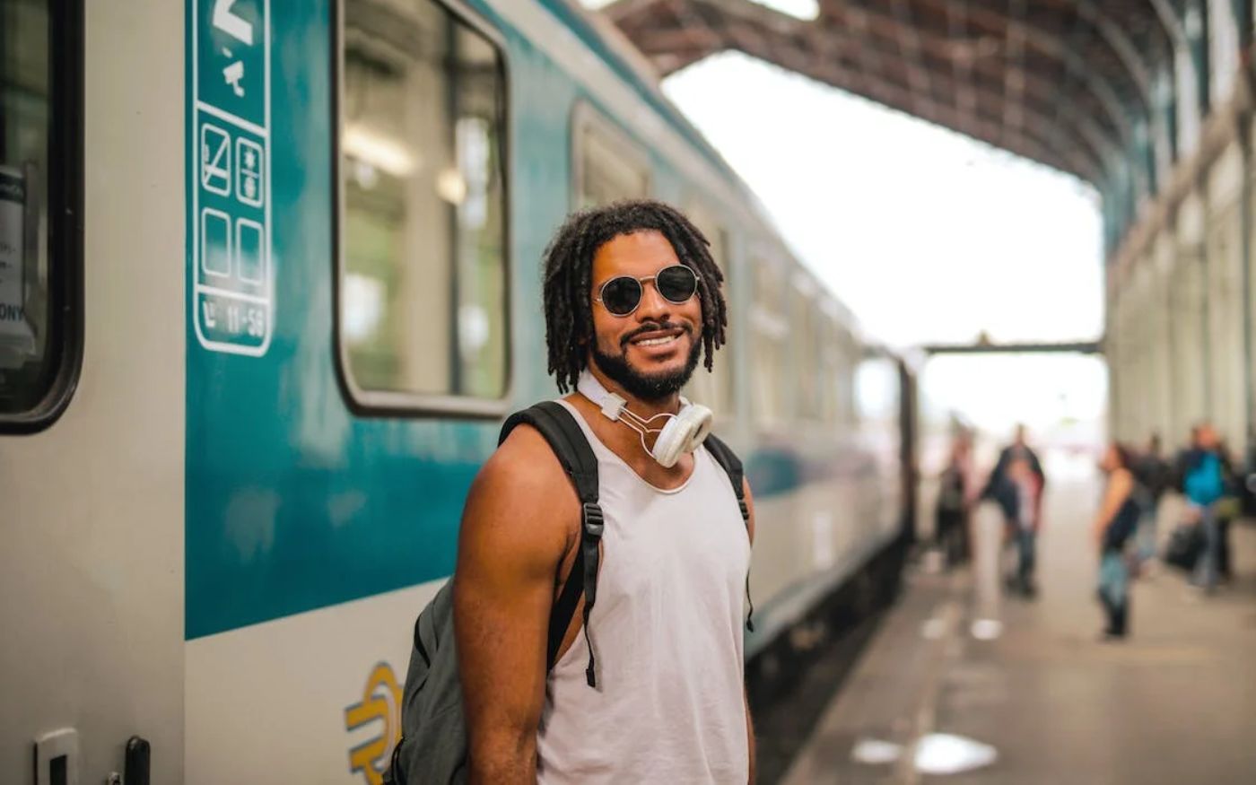 Black man standing in front of a train - long layover in Paris