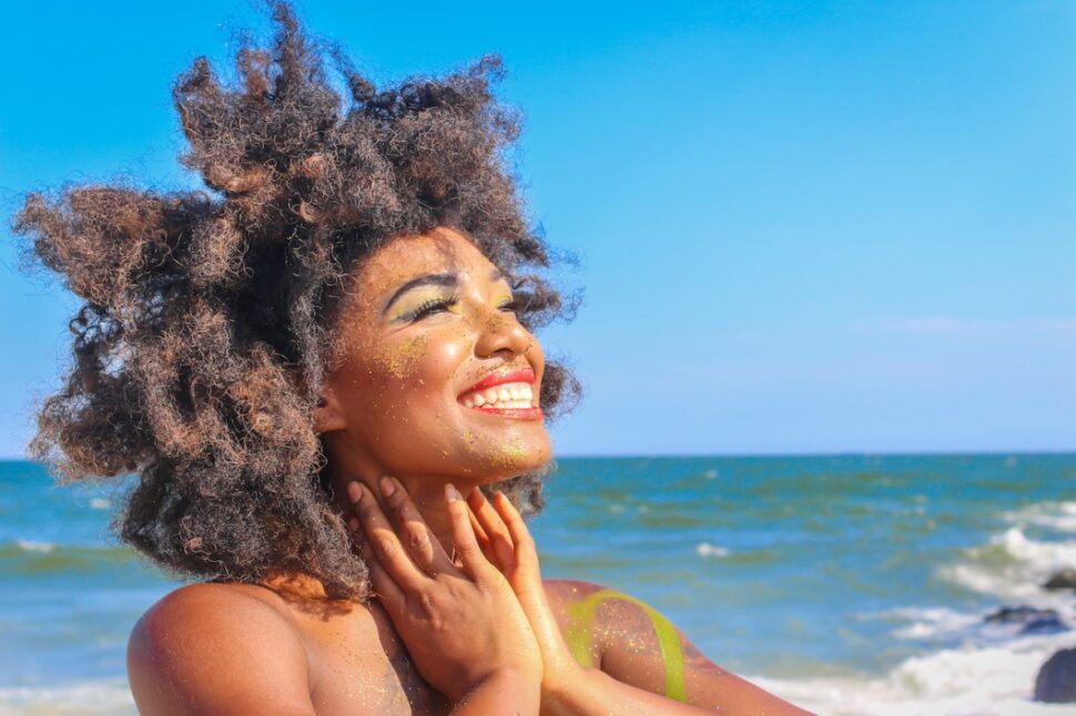 Black woman with natural hair smiling on the beach - Aruba Soul Music Festival