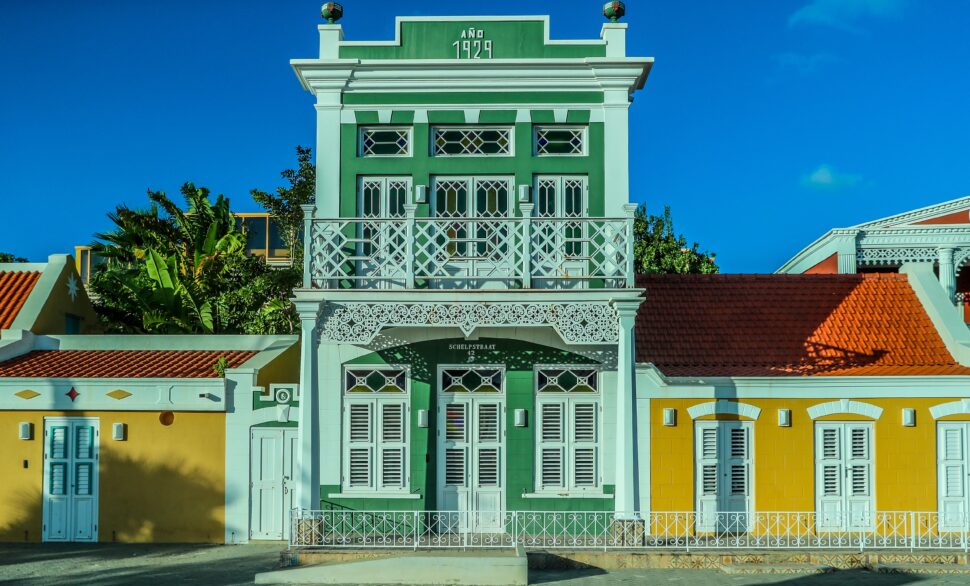 facade of an old green building in Aruba, also known as One Happy Island
