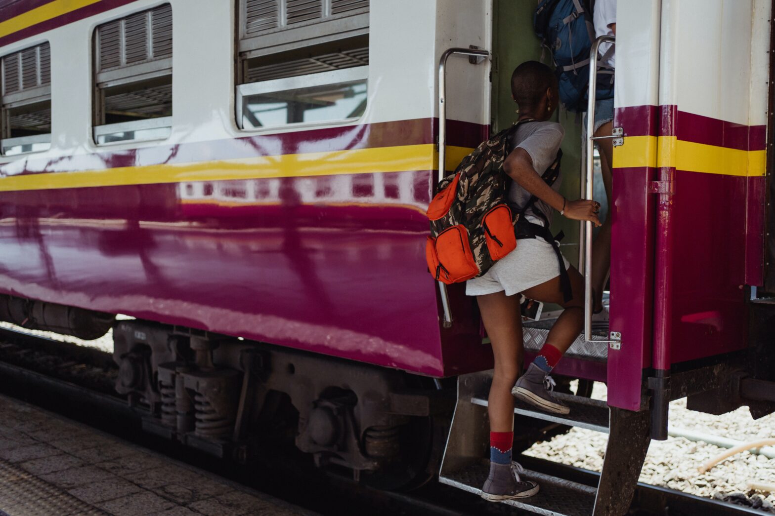 woman with bookbag boarding a train - Best Travel Backpacks for Women