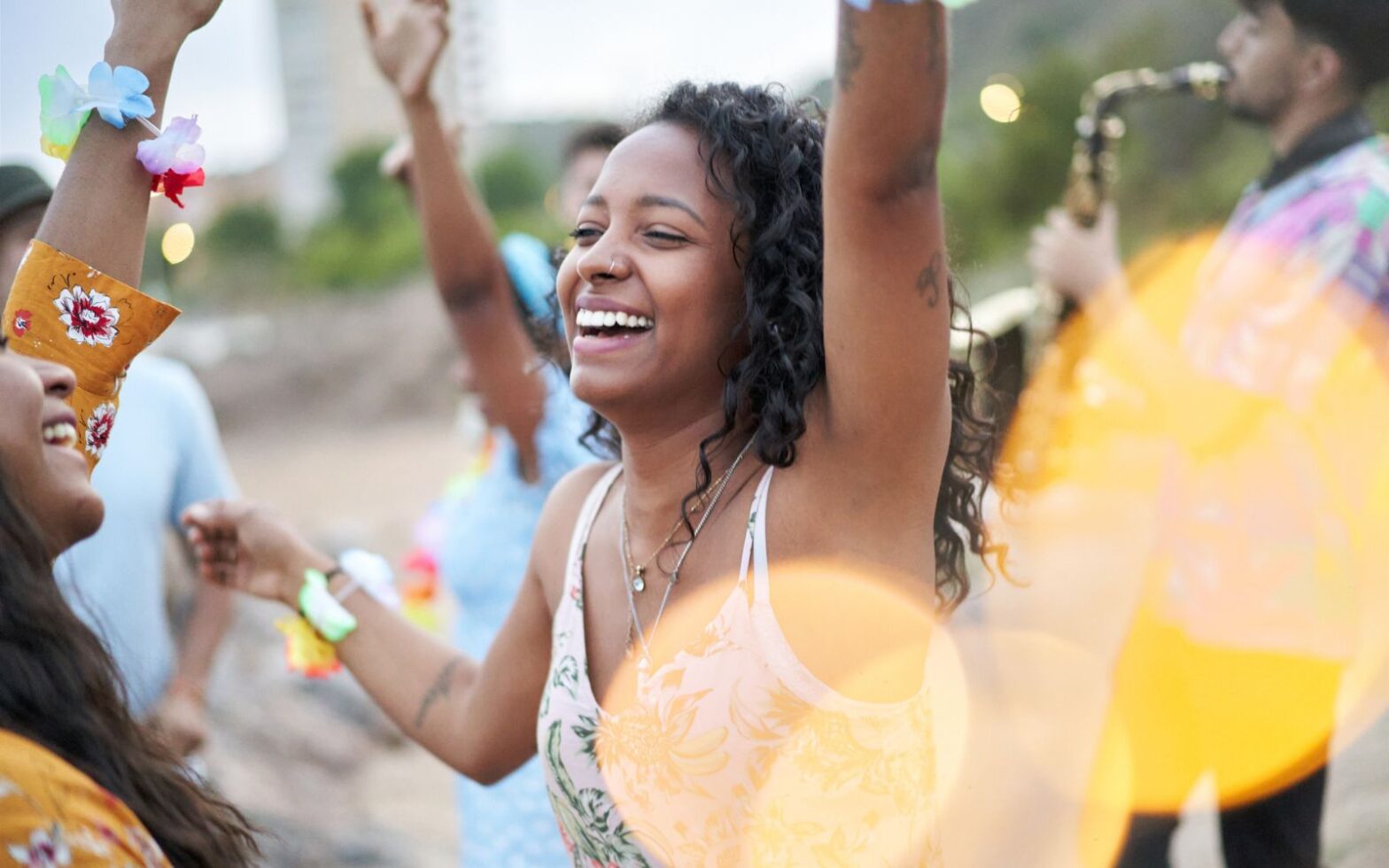 Black woman dancing on the beach - Best cities for Memorial Day Weekend