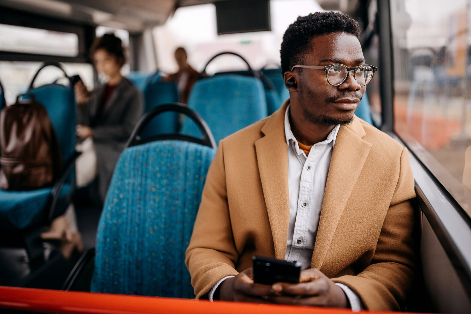 Young man on public bus using mobile phone