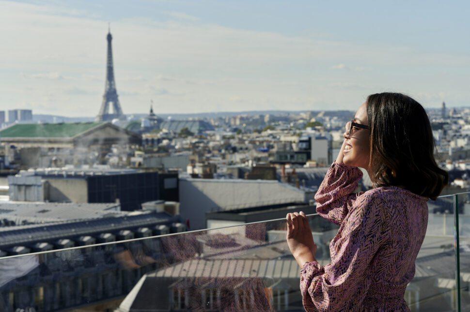 Tourist looking at Eiffel Tower from rooftop, Paris, France