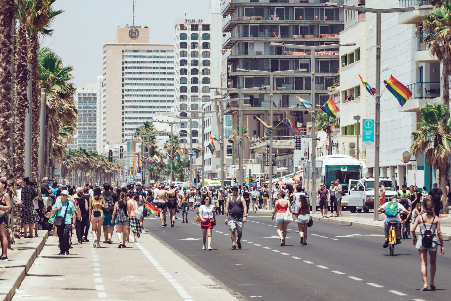People walking on Herbert Samuel street next to Mediterranean beach towards Pride parade marching . Tel Aviv. Israel. June 2018