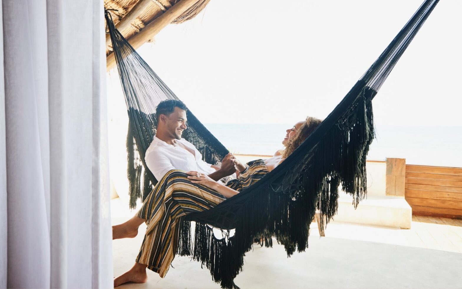 couple sitting in a hammock - most expensive destinations this summer