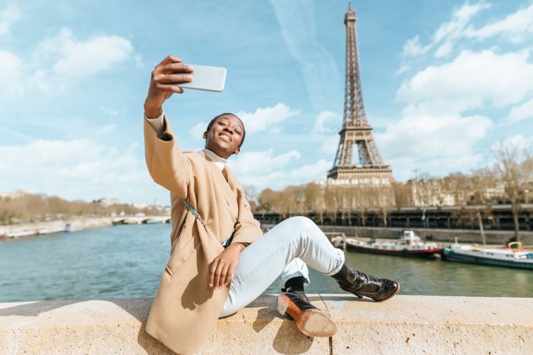 Black woman taking a selfie with the eiffel tower