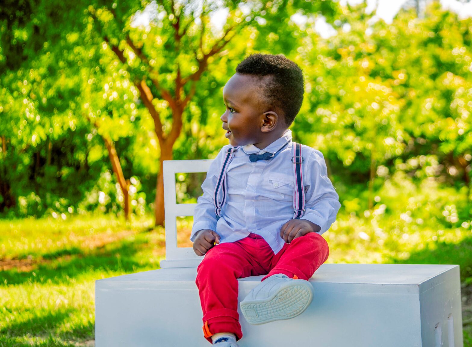 black-baby-boy-wearing-blue-shirt-and-red-pants-sitting-on-table