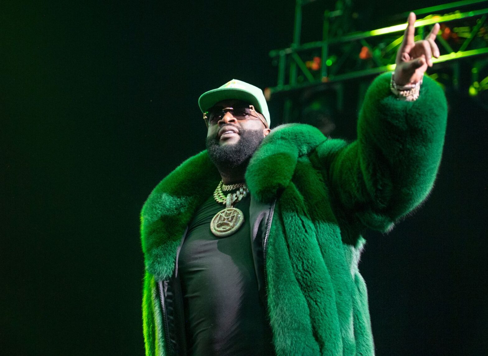 Rick Ross on stage in green fur coat