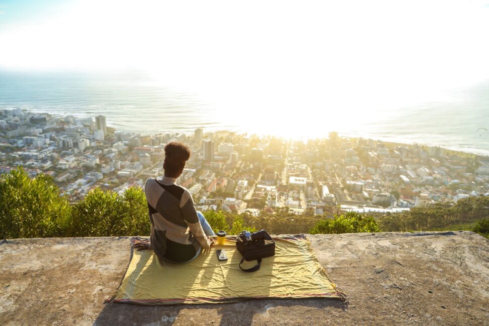 solo traveler sitting on ledge overlooking Cape Town
