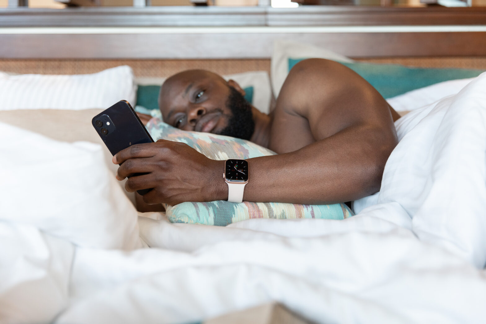 Man laying in bed looking at phone