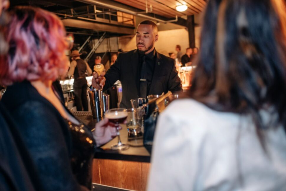man pouring drinks at bar