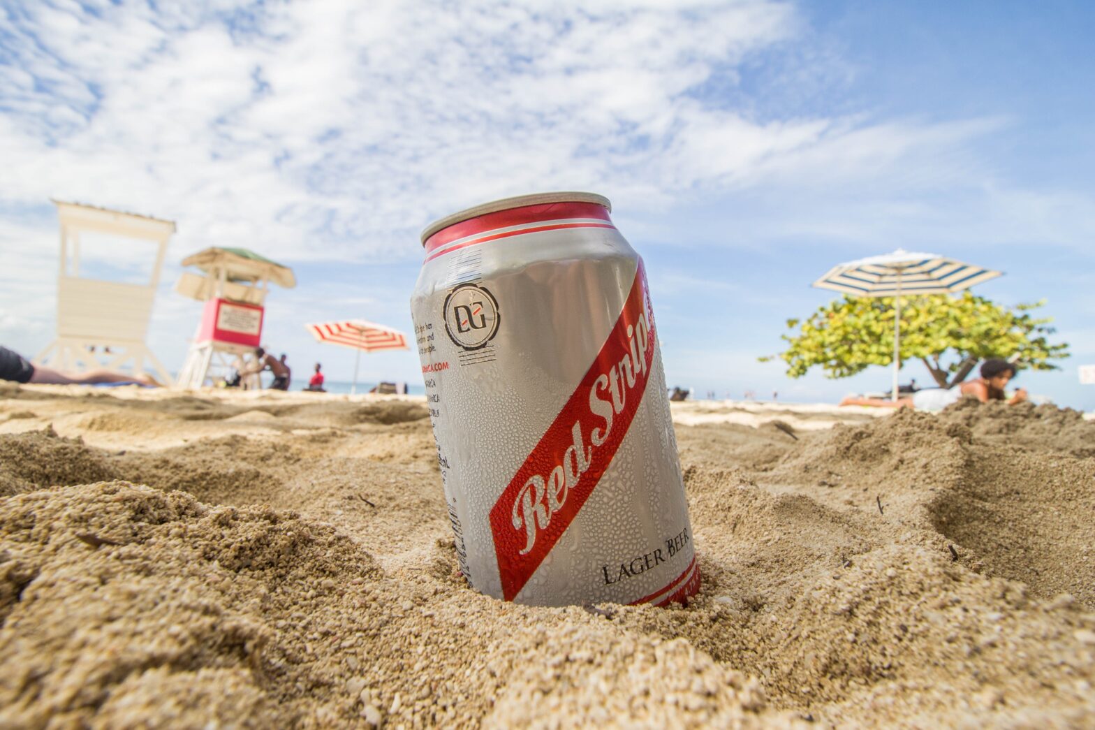 Red Stripe can in sand at beach