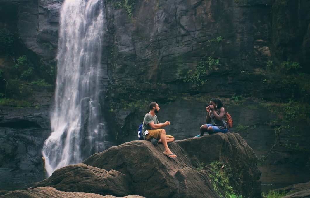 couple sitting outdoors near a waterfall