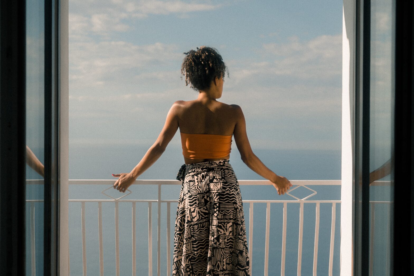 woman on balcony looking at ocean