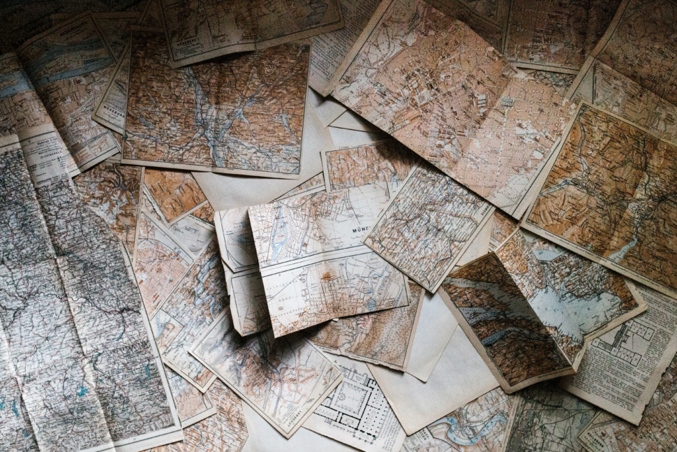 Fly and swap vacations ease international travel concerns and lessen the cost of travel. Pictured: maps on a table.