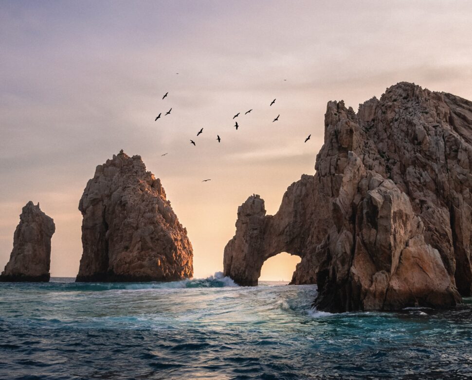Swimming safety is a serious concern when traveling to Cabo if travelers plan to swim. Here are the things to look out for while taking a dip in the Pacific waters to determine if Cabo San Lucas is safe to visit. Pictured: The ocean cliffs and formations of Cabo that can become a threat to swimmers.
