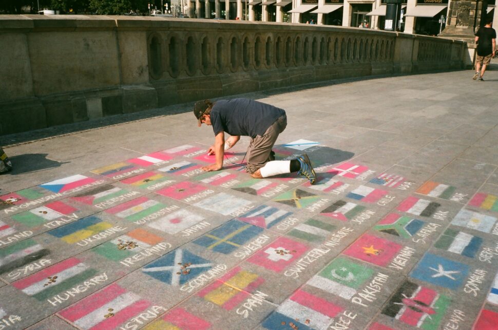 man drawing flags on ground