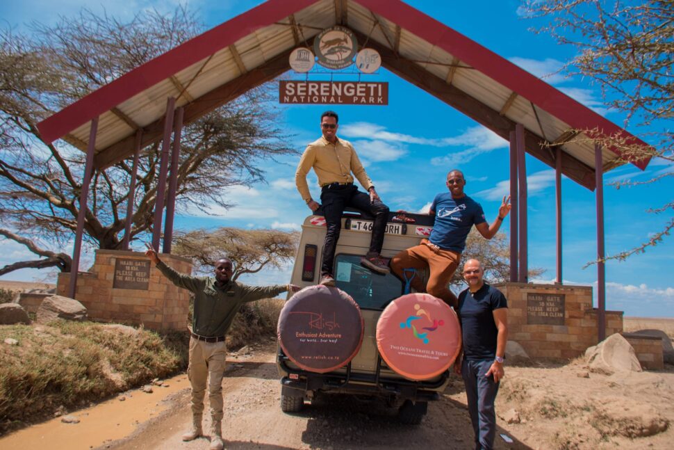 people taking group shot on safari truck - Black-owned travel company, Two Oceans Travel