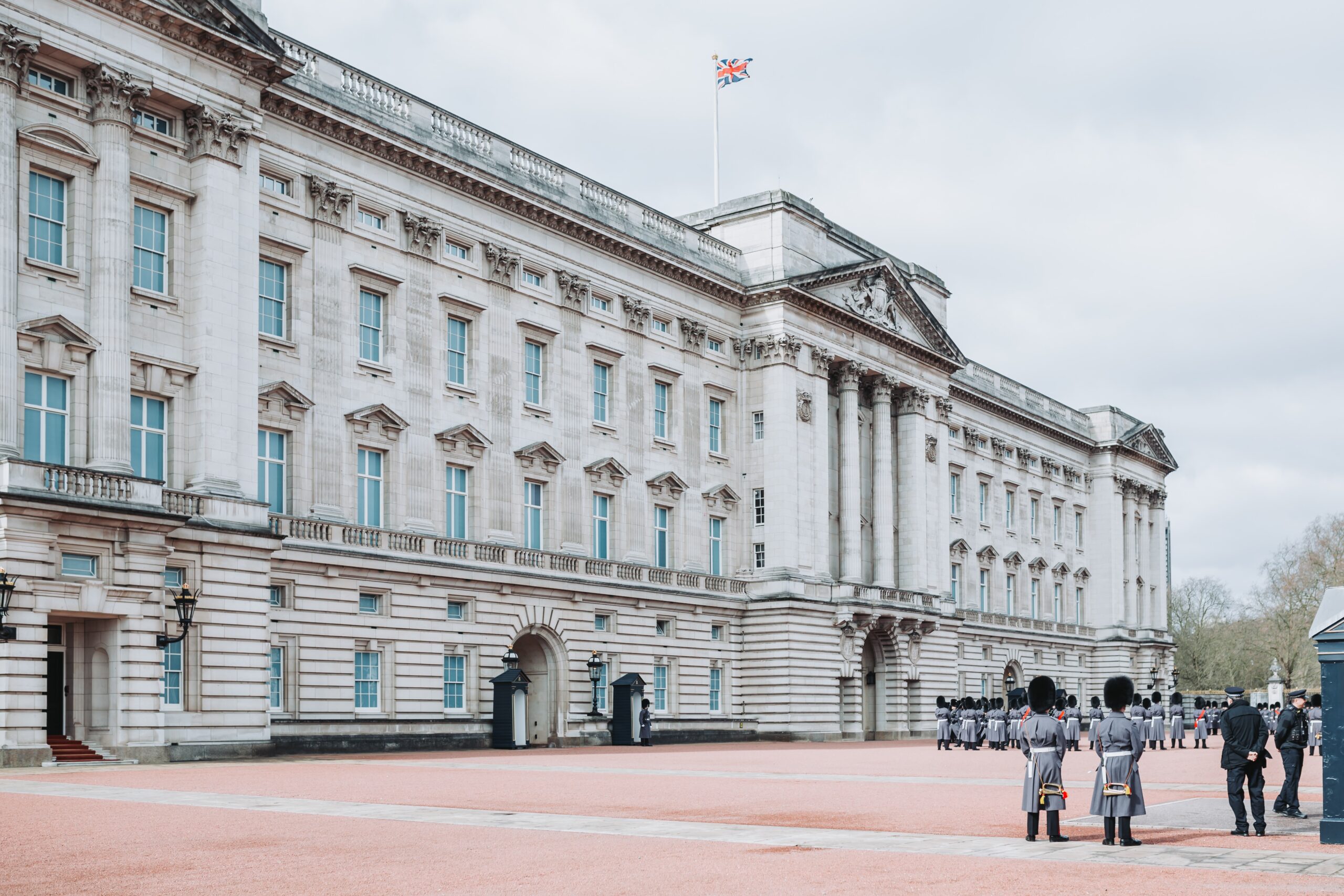Buckingham Palace is a large royal residence that hosts tours for visitors. Learn more about the expansive palace for the next London trip. 
pictured: Buckingham Palace on a sunny day with British Guards lined at the front of its walls
