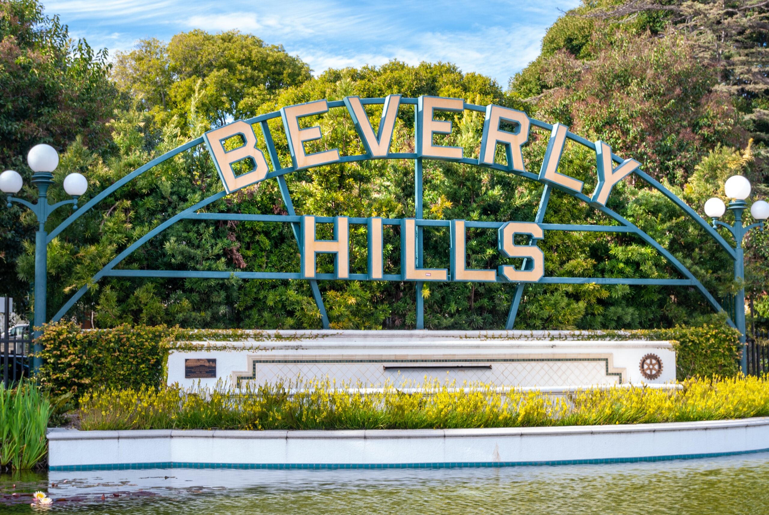 Beverly Hills, California is among the few filming locations of the show Gilmore Girls. 
pictured: The Beverly Hills sign in California in front of well trimmed hedges 