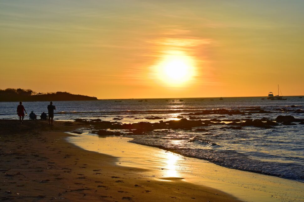 A group walking on the beach in Tamarindo at sunset