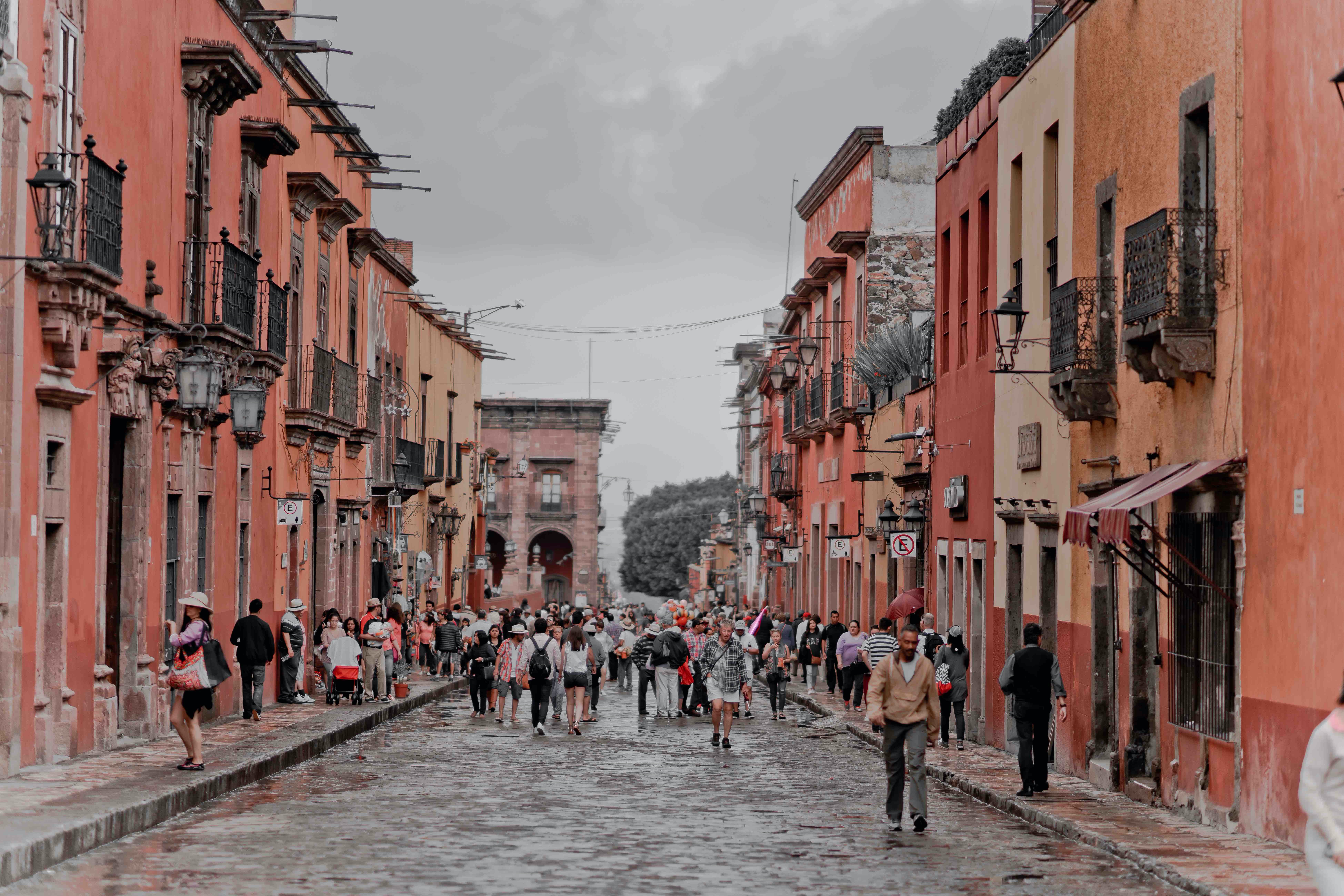 There are plenty of places for visitors to stay in Guadalajara, but these places are the best for travelers concerned with safety. 
pictured: a residential area of Mexico with pedestrians walking in the streets 