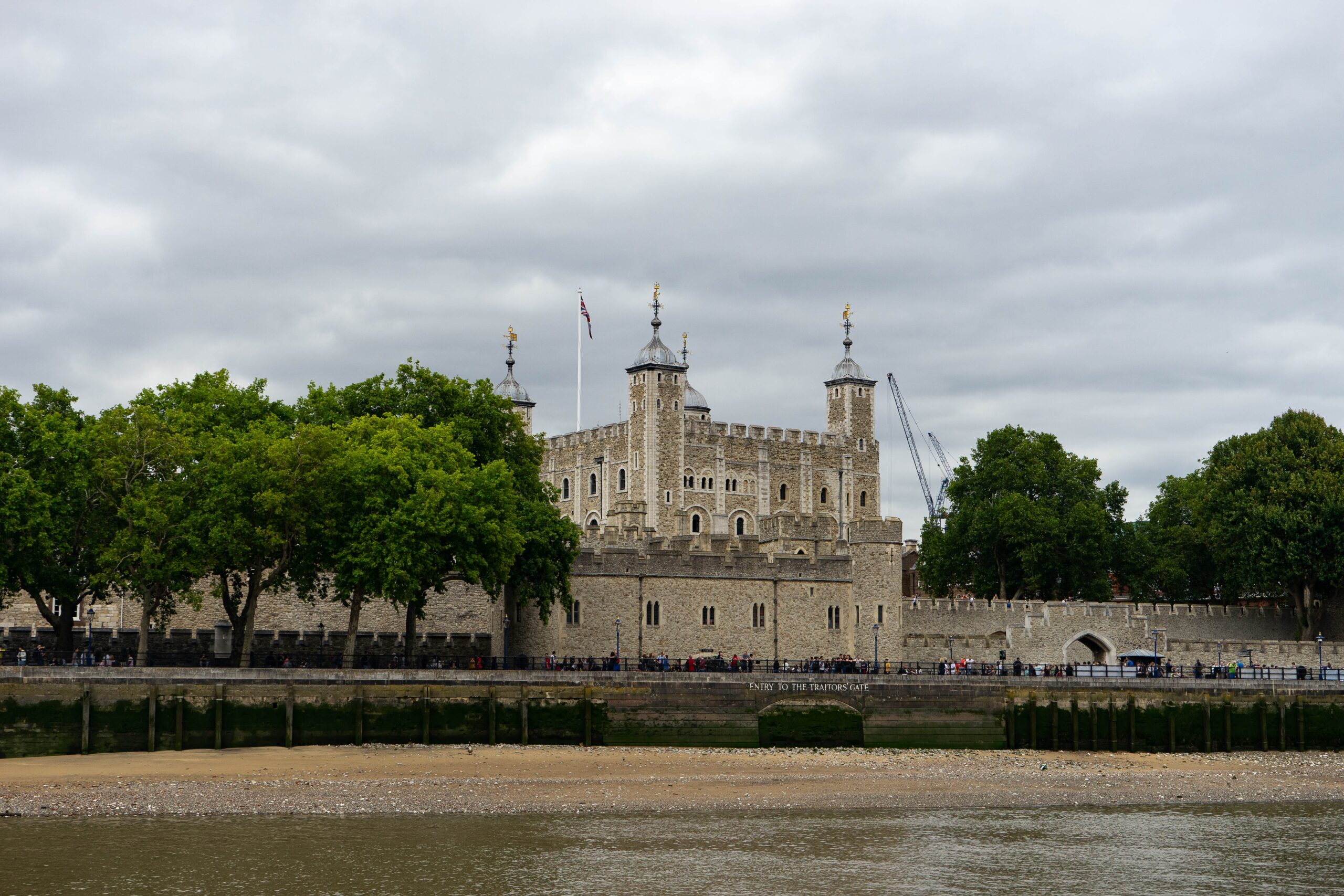 The Tower of London is a stunning fortress that attracts many tourists. 
pictured: The Tower of London on a cloudy day, surrounded by trees 