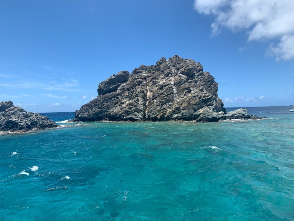 A Large rock surrounded by the ocean in St. Barts. 