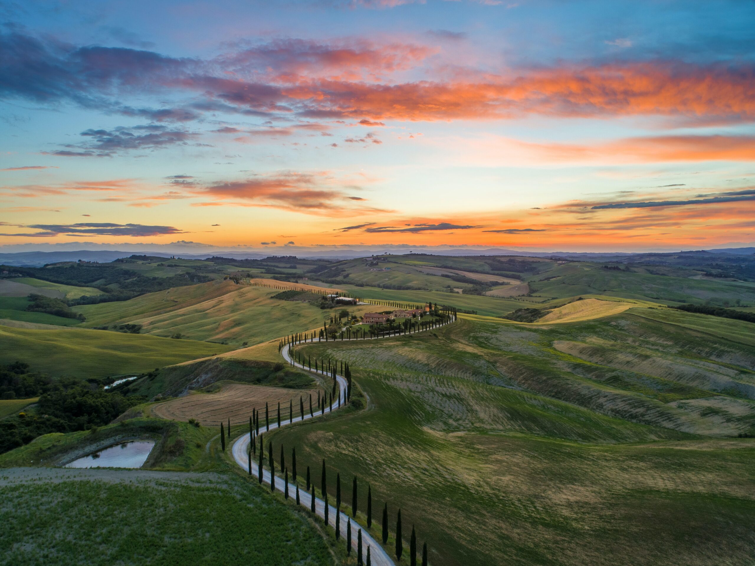 Tuscany is one of the most well known countryside regions of Italy. Check out what the area has to offer travelers. 
pictured: A stunning amber sunset over a winding road and bountiful hills in Tuscany, Italy