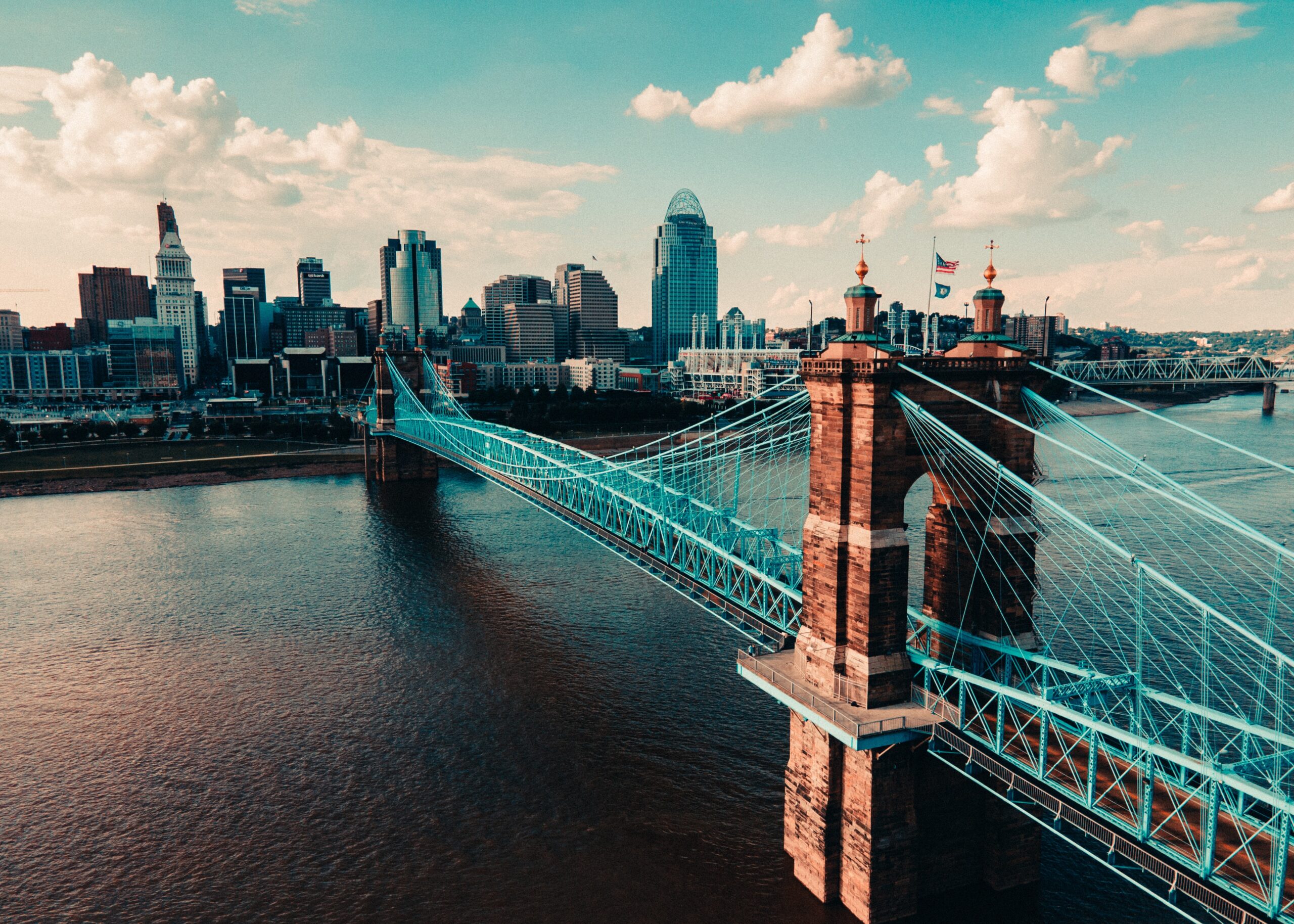 Cincinnati is a relatively safe place to visit. Check out the best places to stay to have a safe trip. 
pictured: The Cincinnati bridge and river on a bright cloudy day 