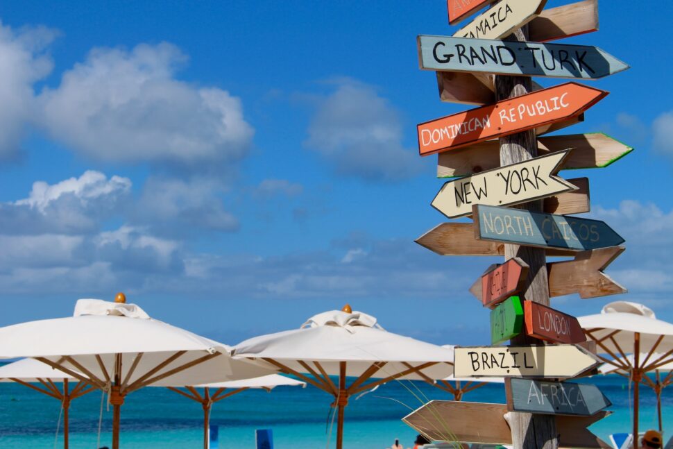 Signs pointing to different locations on a beach in Turks and Caicos.