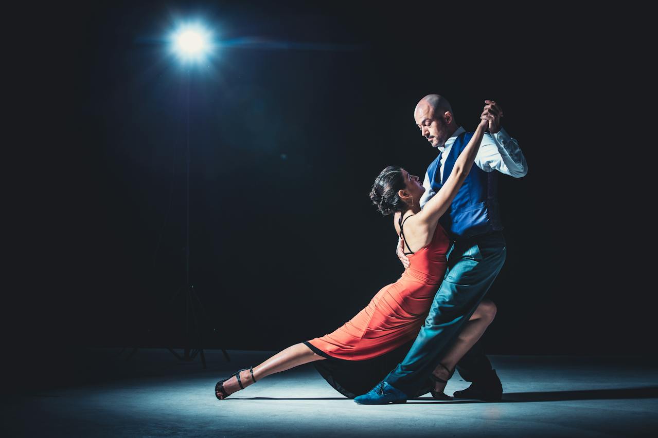 Two tango dancers on a dark stage
