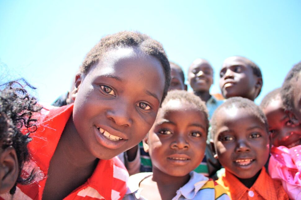 A close-up of young children smiling at the camera