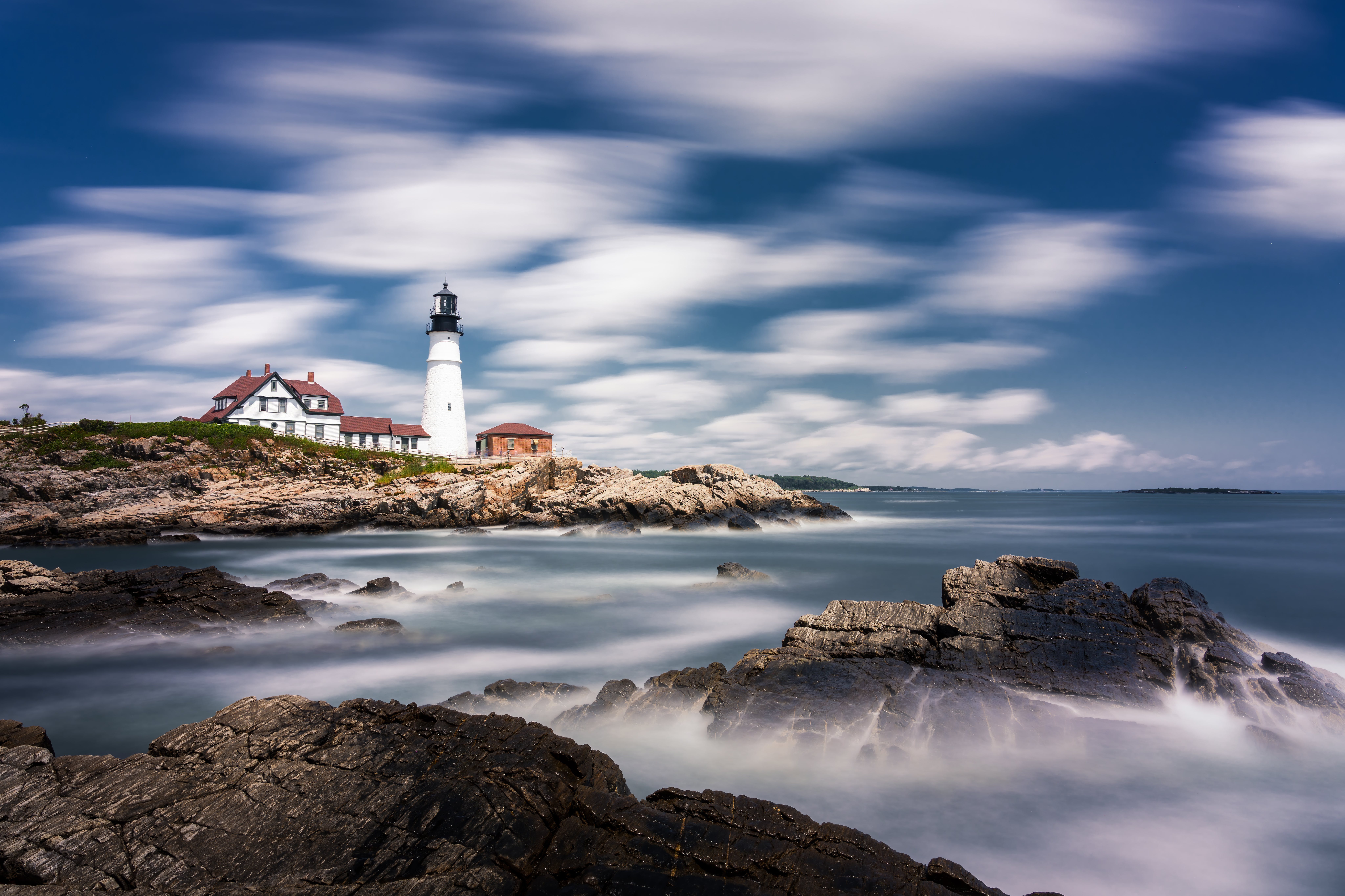 There are many exiting things to do in the many states of New England.
pictured: a New England coast with a light house and surrounding house on a cloudy day 