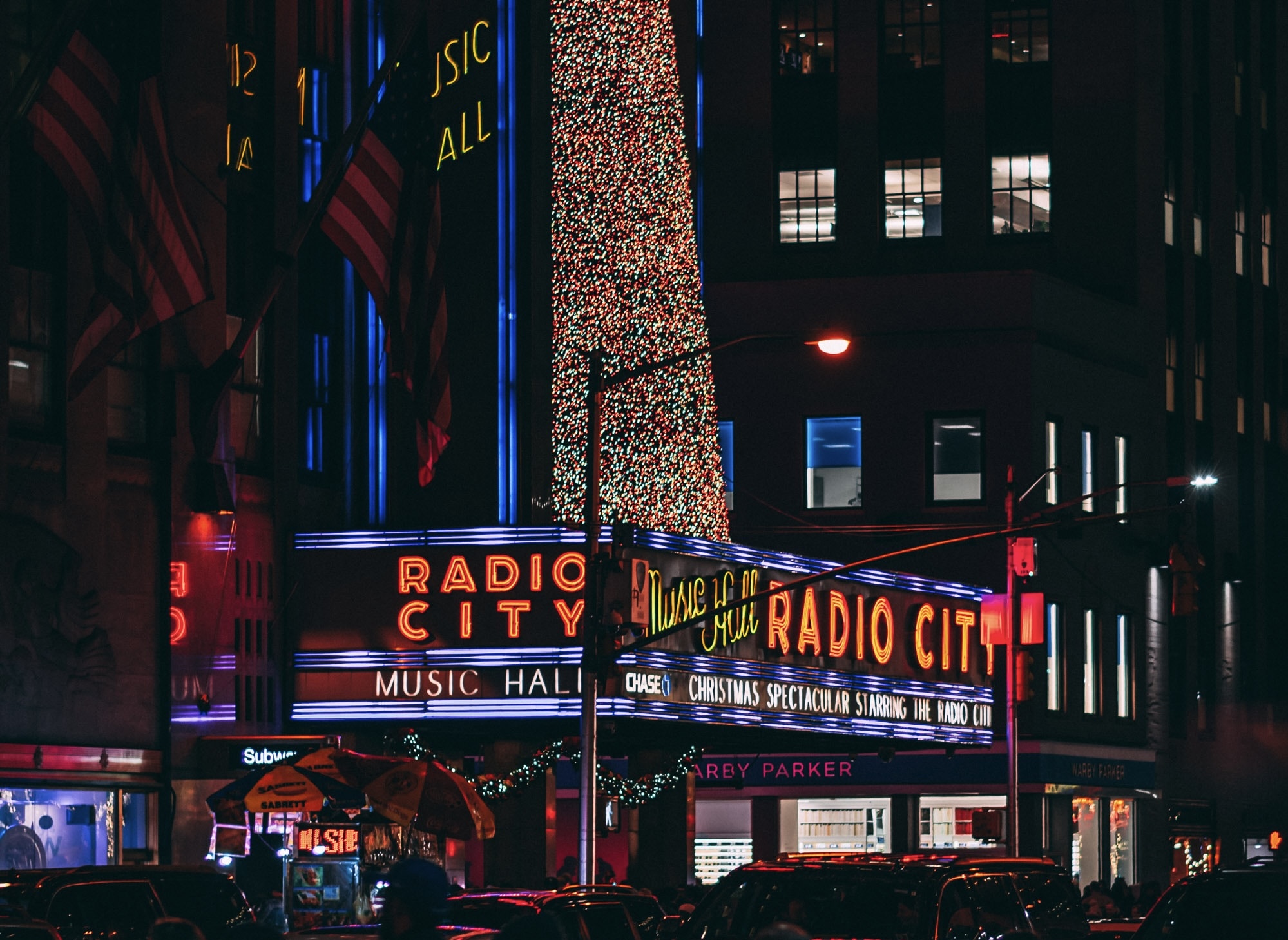 Radio City is a historic attraction which hosts the annual Christmas Spectacular. 
Pictured: the Radio City Music Hall and Christmas Special advertisements at night with Christmas lights shining 