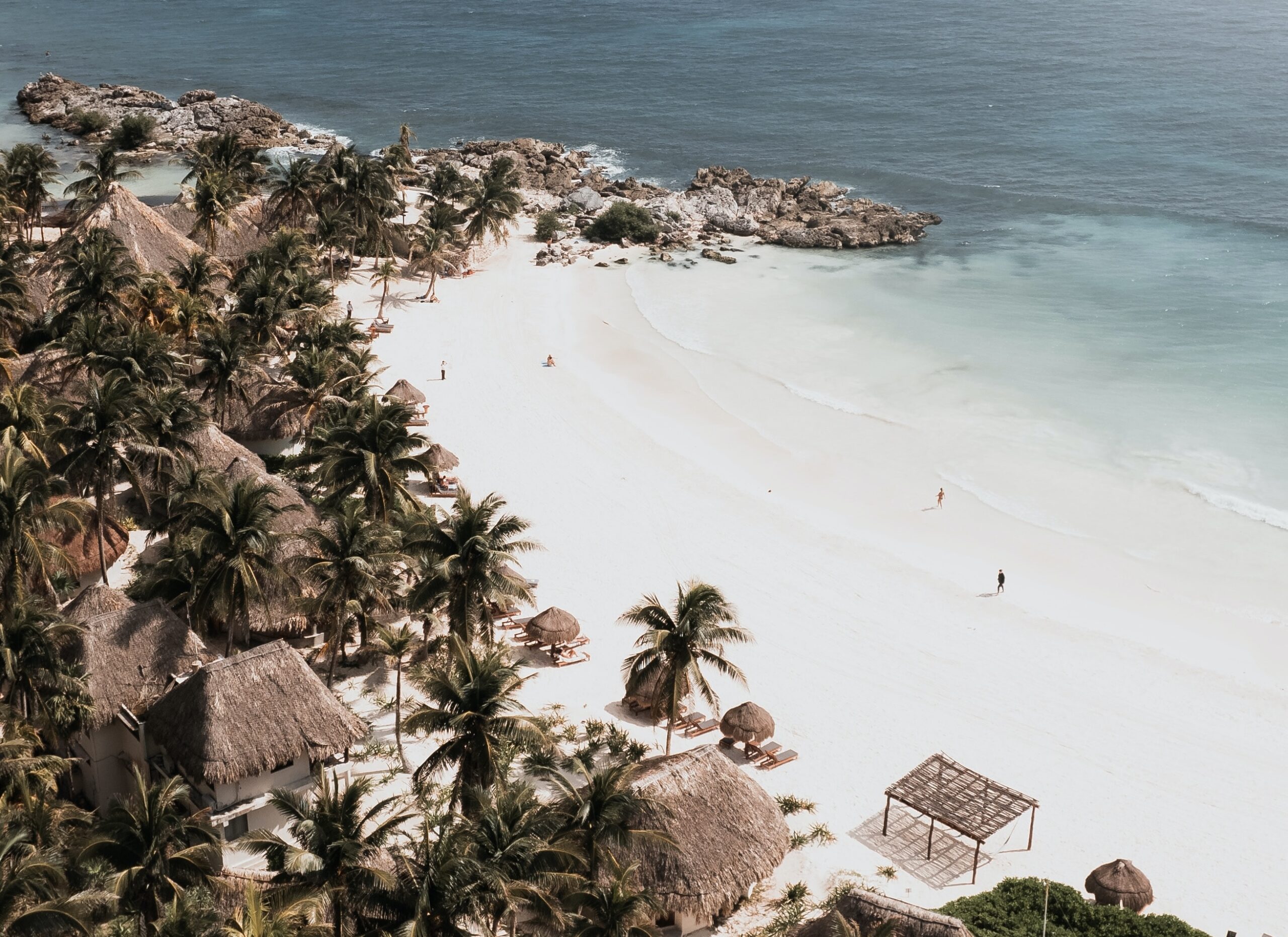 Learn more about one of the best resorts in Tulum, which is an all-inclusive experience. 
Pictured: A Tulum beach with resort huts surrounding the sandy coast