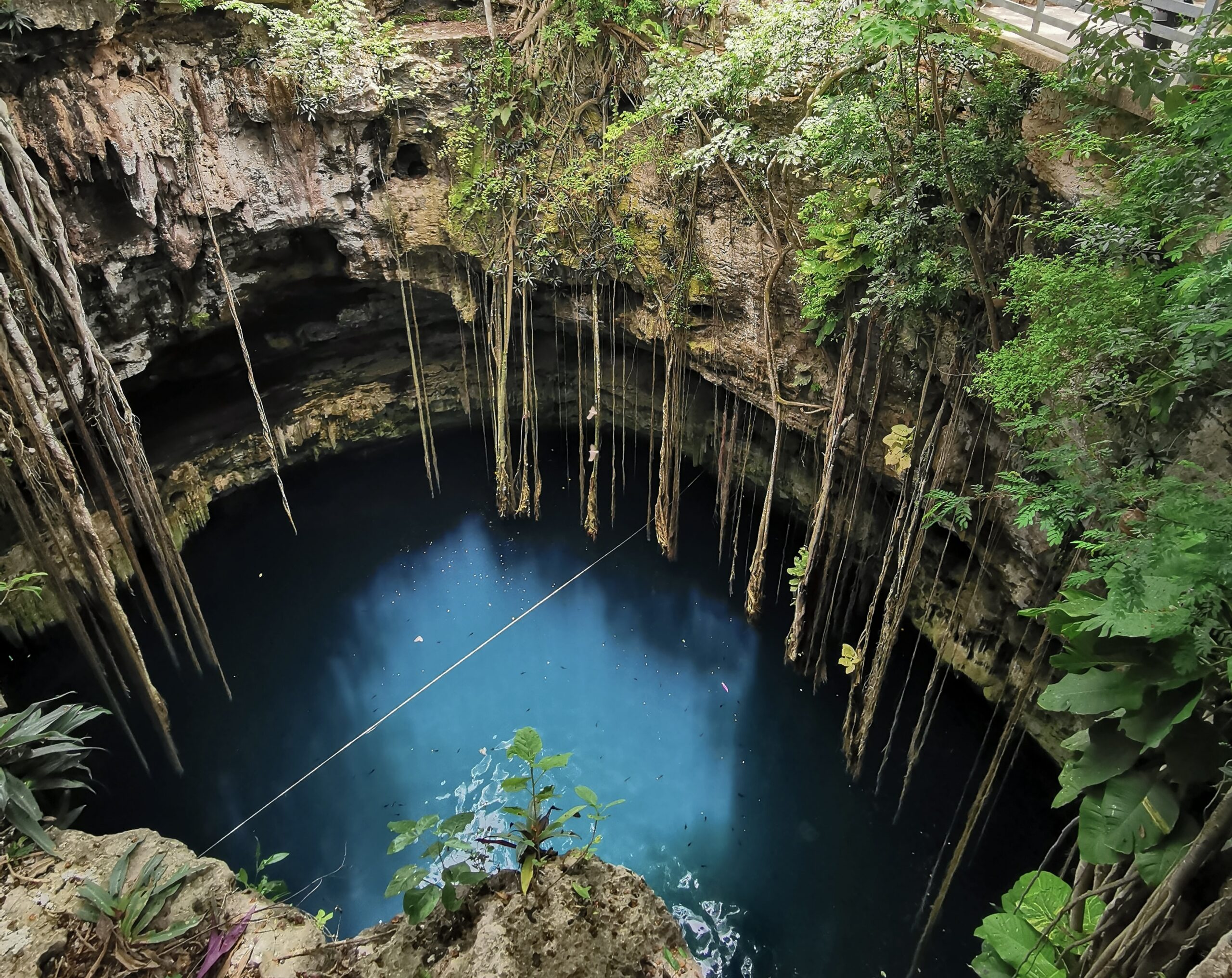 The safe city of Merida is a serene location for vacationers that desire a Mexico trip.
Pictured: a waterfall leading into a cenote in Merida, Mexico 