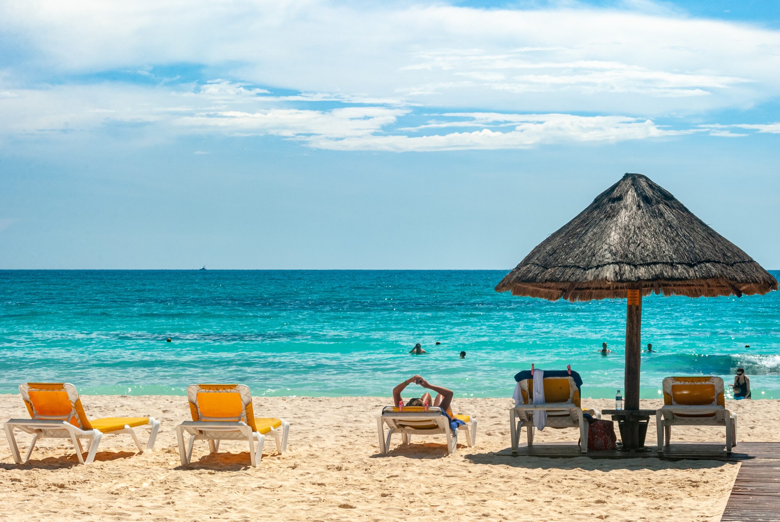 Cancun is a very popular destination in Mexico that is considered a safe place to visit. 
Pictured: a beach in Cancun with chairs on the warm sand and clear blue waters 