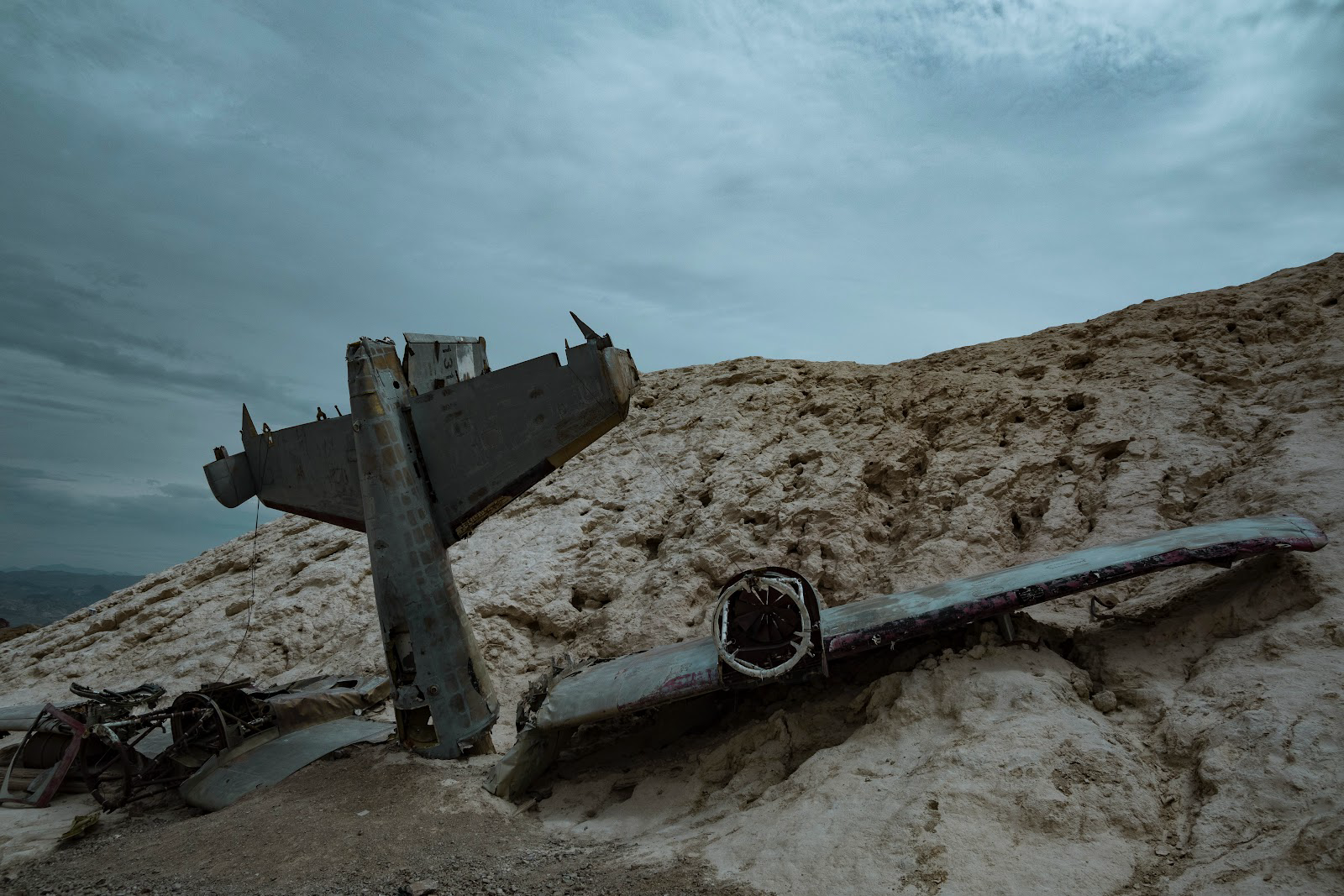 Boneyards are locations that old planes go to retire. Check out the facts and tips for travelers that want to visit.
Pictured: plane parts in a boneyard, the location is gloomy and dry 