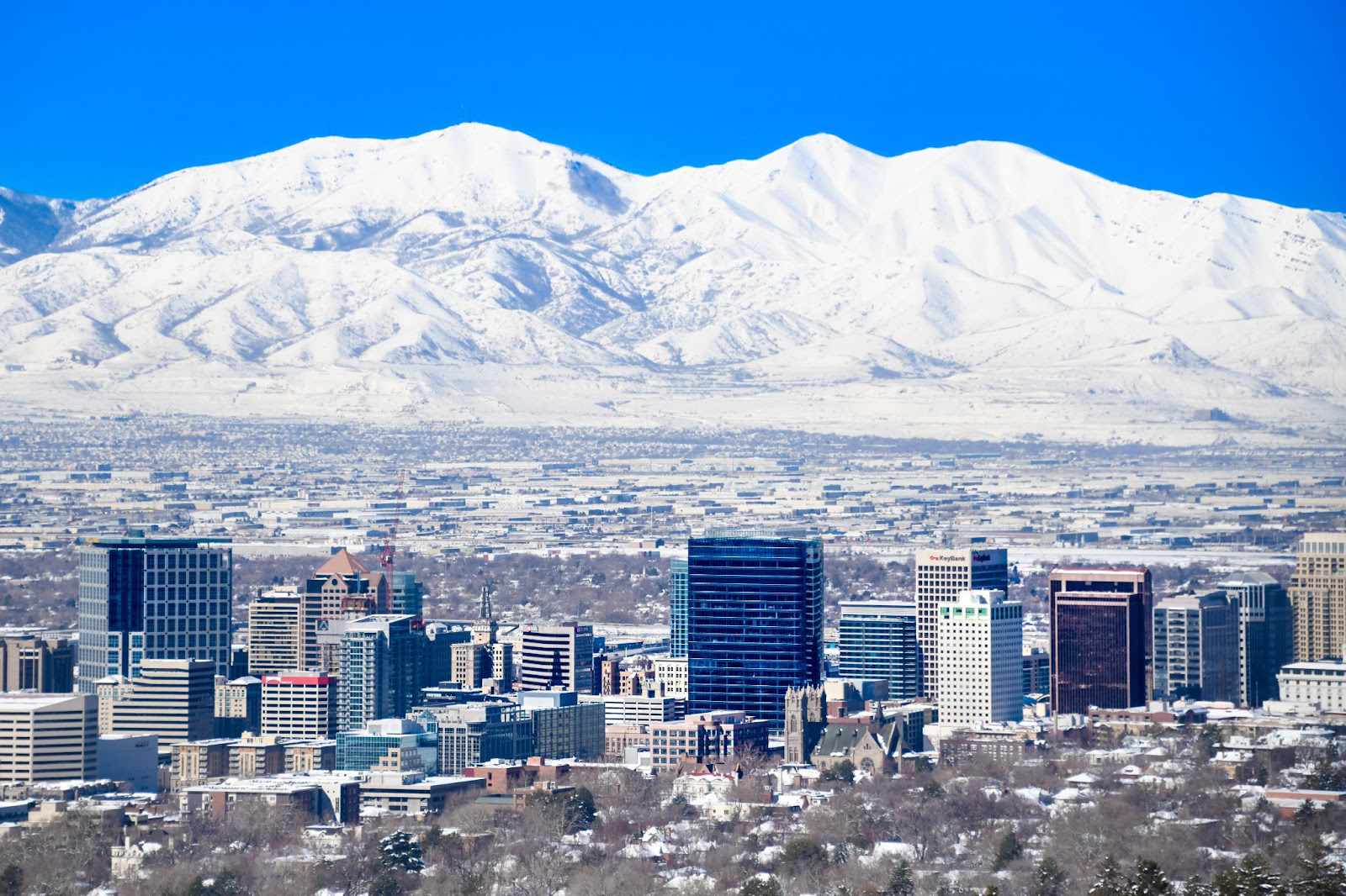 Salt Lake City is a popular city of Utah that is a filming location for the new Lindsay Lohan Christmas movie. 
Pictured: a view of Salt Lake City with snow capped mountains and the cityscape 