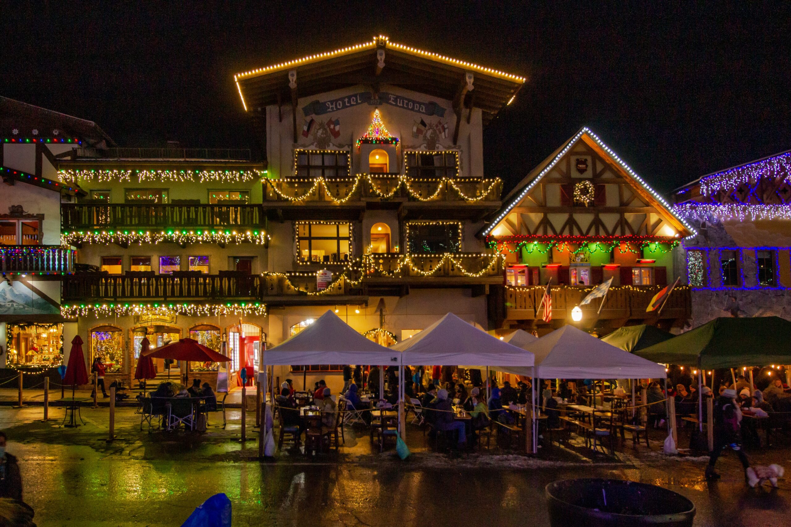Leavenworth is a pacific northwestern village which has a popular Christmas theme. 
pictured: the village of Leavenworth lit up with Christmas lights and filled with people 