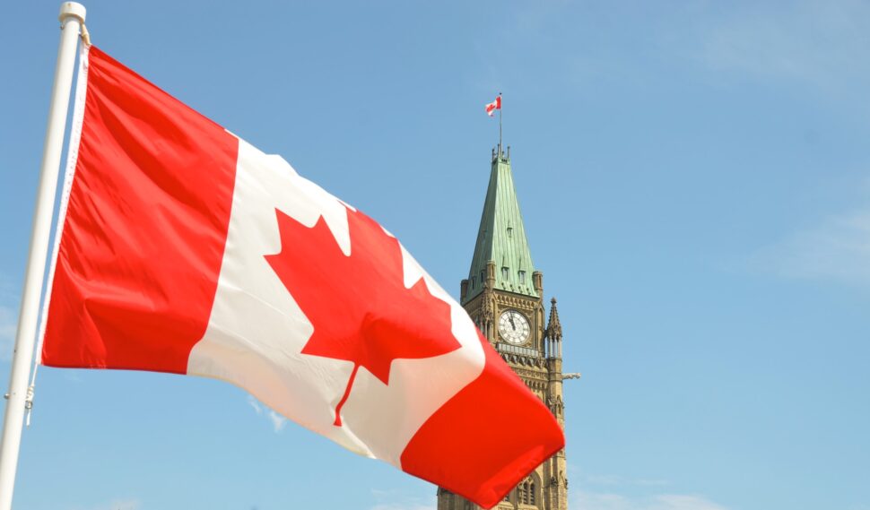 Canadian flag waving in front of the Parliament Building